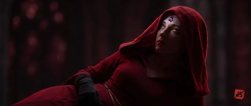 A red-hooded face lit from below, eyes lifted at the moment of understanding.