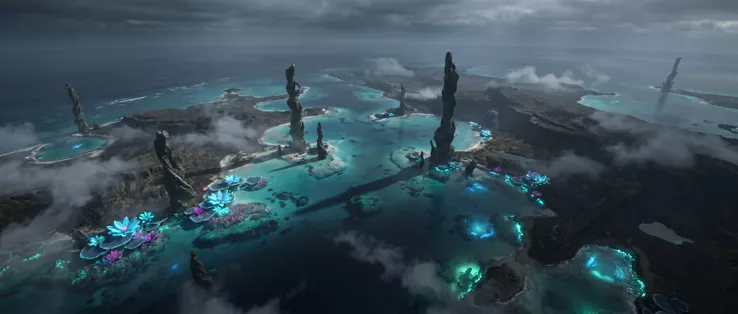An aerial view of an archipelago: pale lagoons, dark stone spires standing out of the water, colonies of glowing blue and magenta flowers, cloud shadow over everything